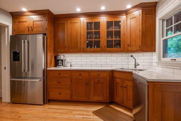 Elegant kitchen with glass-door cabinets displaying select items, featuring patterned glass.