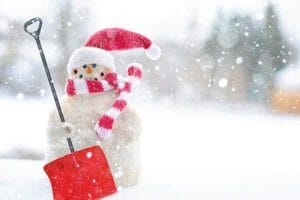 Snowman holding a red snow shovel.