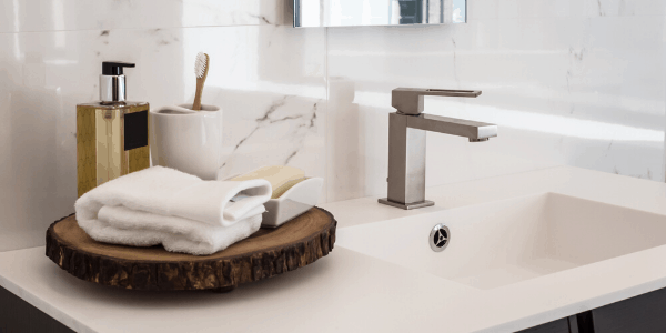 Close-up of a modern bathroom vanity and sink with toiletries arranged on the counter.