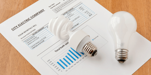 Lightbulbs sit on top of an electrical billd depict the benefits of an energy-efficient bathroom