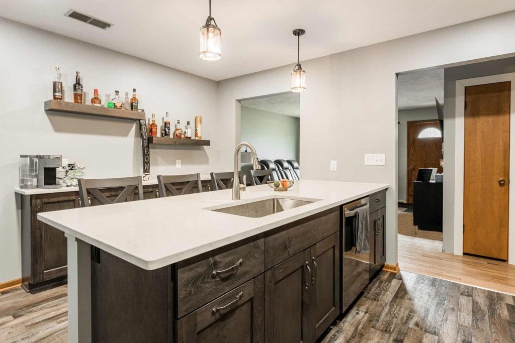 Minimalistic kitchen with open cabinetry displaying stylish dishware, featuring shelves in matching wall color and wood accents