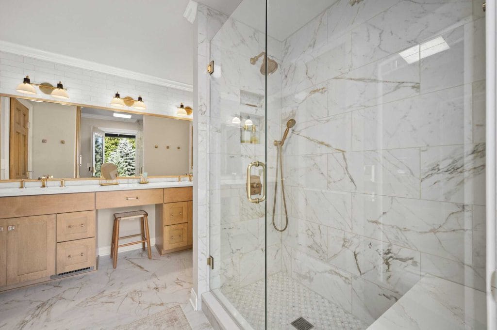 Bathroom remodel with marbeled tiling with a caption reading "Luxury."