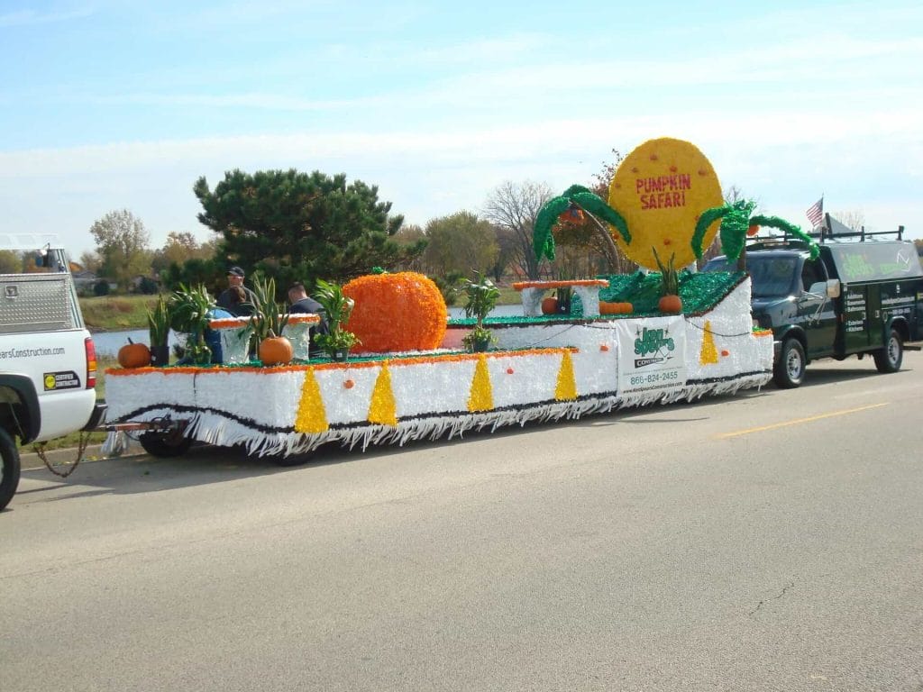 Colorful parade float with pumpkins and safari theme.