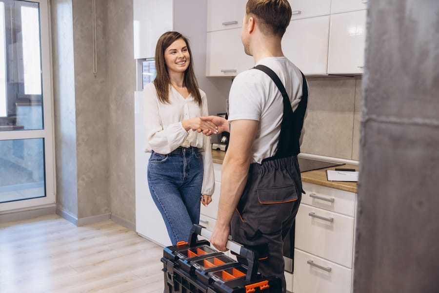 A Spears Design Build Group employee shakes hands with a homeowner after a project.