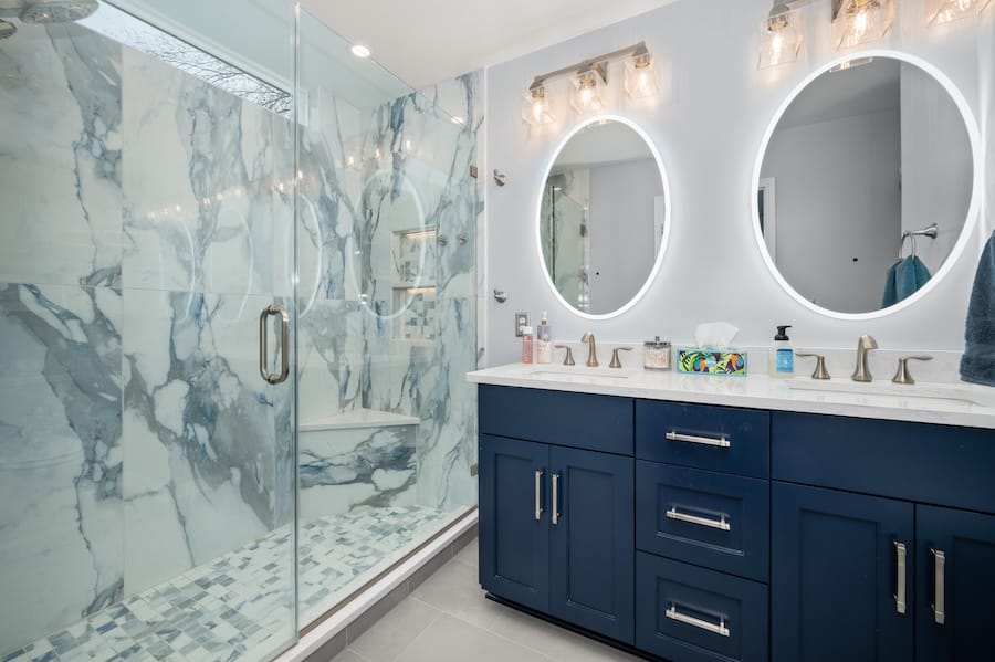 Master bathroom refresh showing off new vanity, mirrors, and shower with marble tile.