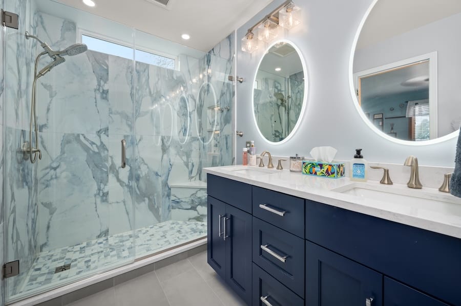 Master bathroom refresh showing off new vanity, mirrors, and shower with marble tile.